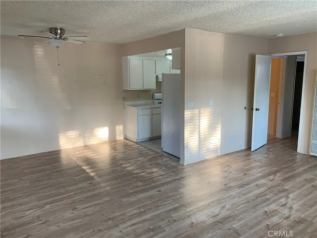 a view of empty room with wooden floor and window