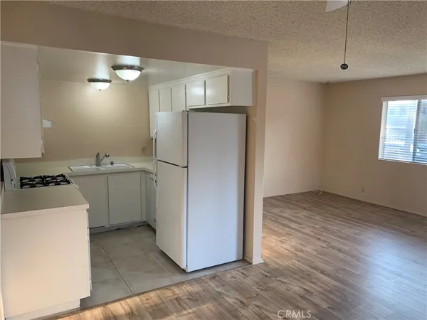 a kitchen with a refrigerator sink and cabinets