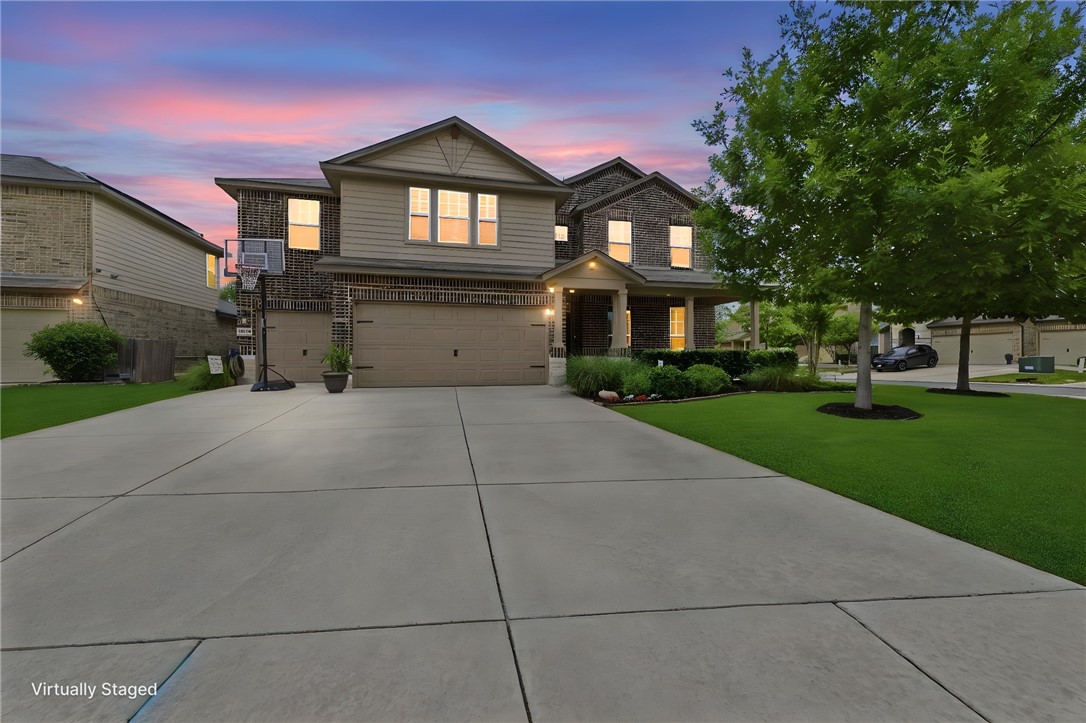 a front view of a house with a yard and trees