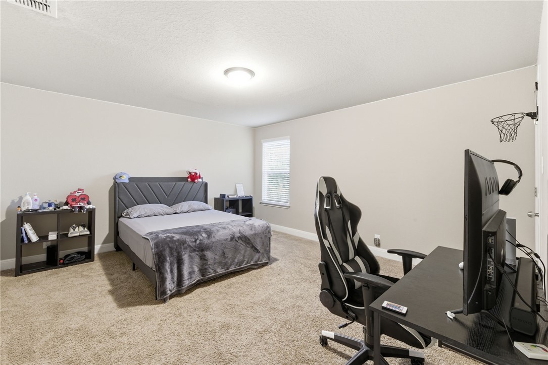 8826 Virginia Rye San Antonio, TX 78254 - Photo 20 of 40 a bedroom with a bed a desk and chair