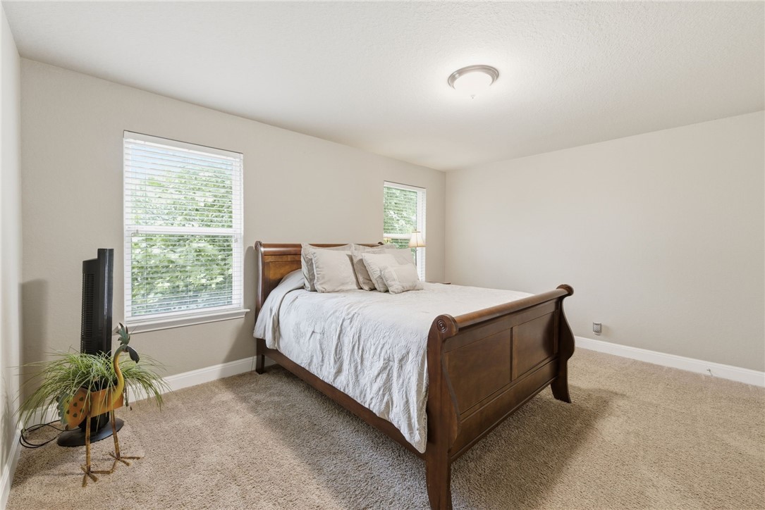 8826 Virginia Rye San Antonio, TX 78254 - Photo 21 of 40 a bed sitting in a bedroom next to a window