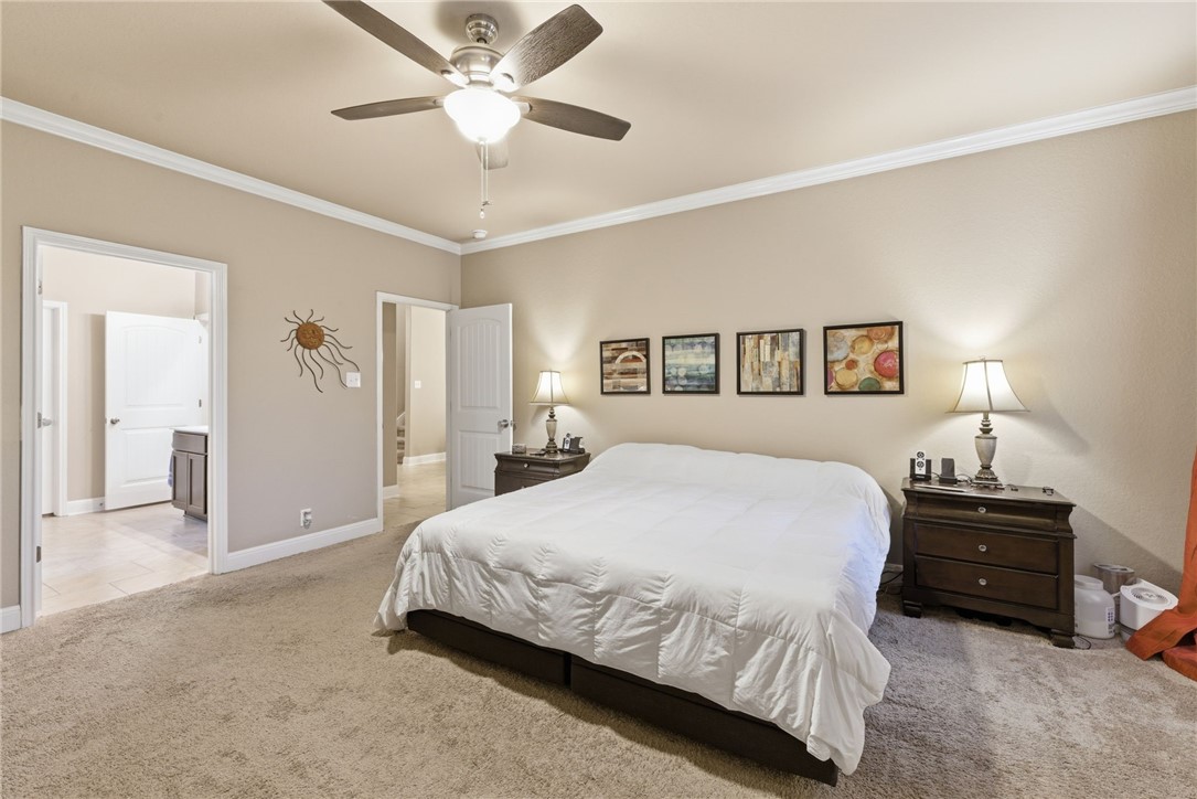 8826 Virginia Rye San Antonio, TX 78254 - Photo 36 of 40 a spacious bedroom with a bed and a chandelier