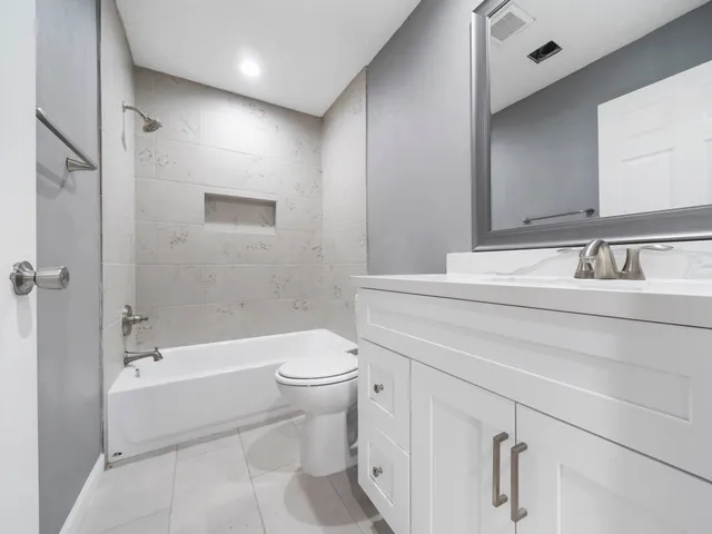 a bathroom with a bathtub toilet sink vanity and shower