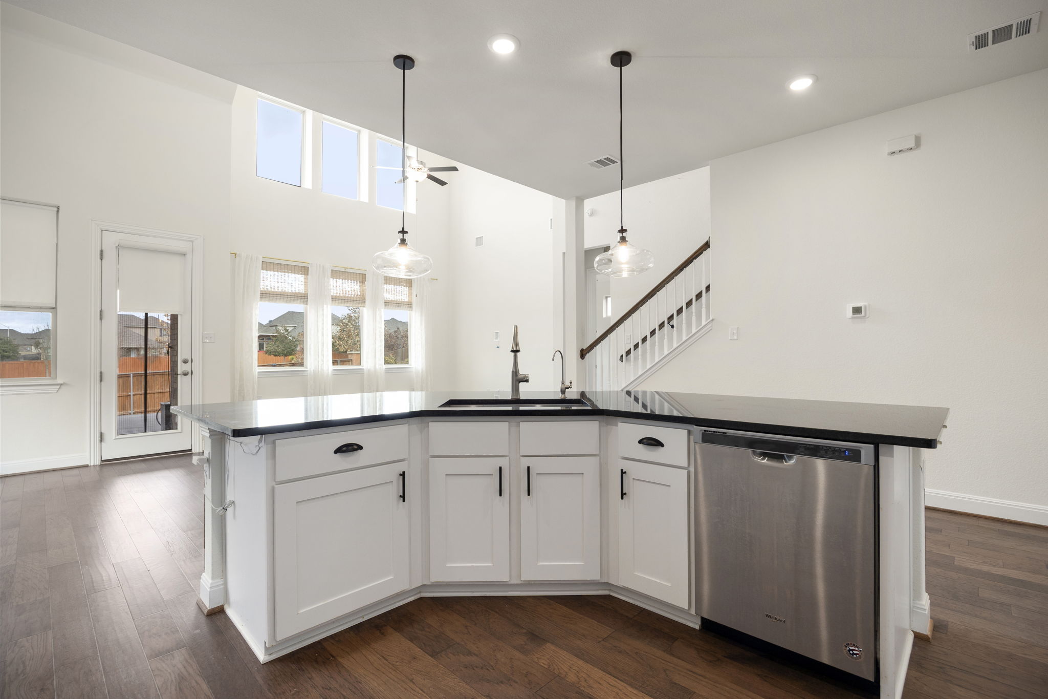 1098 Cherrystone Loop Buda, TX 78610 - Photo 6 of 37 a kitchen with granite countertop a sink a center island a counter space and a window