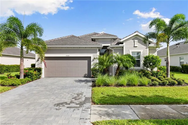 a front view of a house with a yard and potted plants