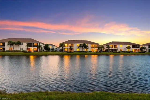 a view of a swimming pool with lawn chairs under an umbrella