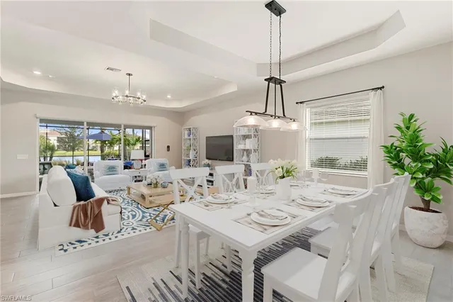 a living room with furniture a flat screen tv and kitchen view