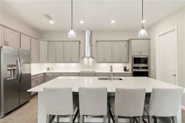 a kitchen with a dining table chairs sink and cabinets
