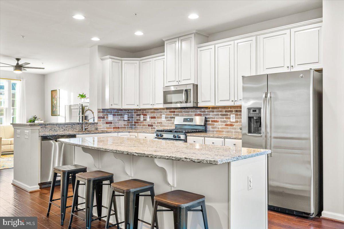 4535 Tinder Monrovia, MD 21770 - Photo 11 of 61 a kitchen with stainless steel appliances granite countertop a table chairs refrigerator and sink