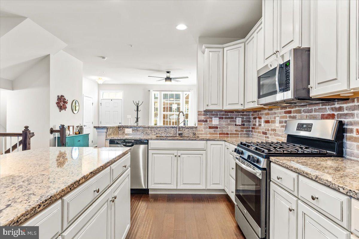 4535 Tinder Monrovia, MD 21770 - Photo 12 of 61 a kitchen with stainless steel appliances granite countertop a sink stove and cabinets