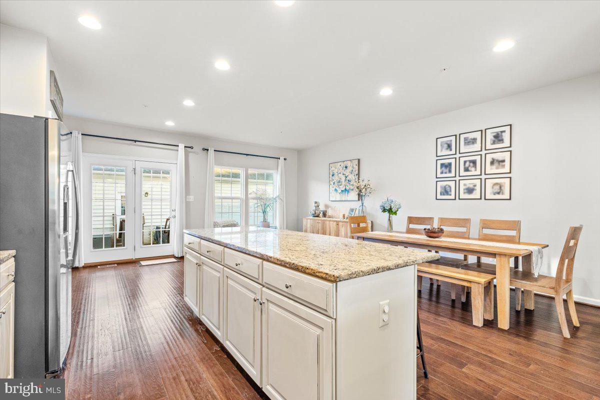 4535 Tinder Monrovia, MD 21770 - Photo 13 of 61 a kitchen with a stove a sink a dining table and chairs with wooden floor