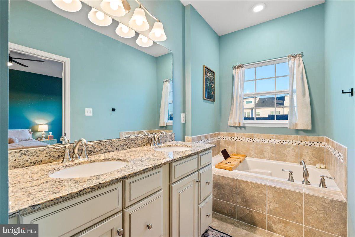4535 Tinder Monrovia, MD 21770 - Photo 24 of 61 a bathroom with a granite countertop sink mirror and bathtub