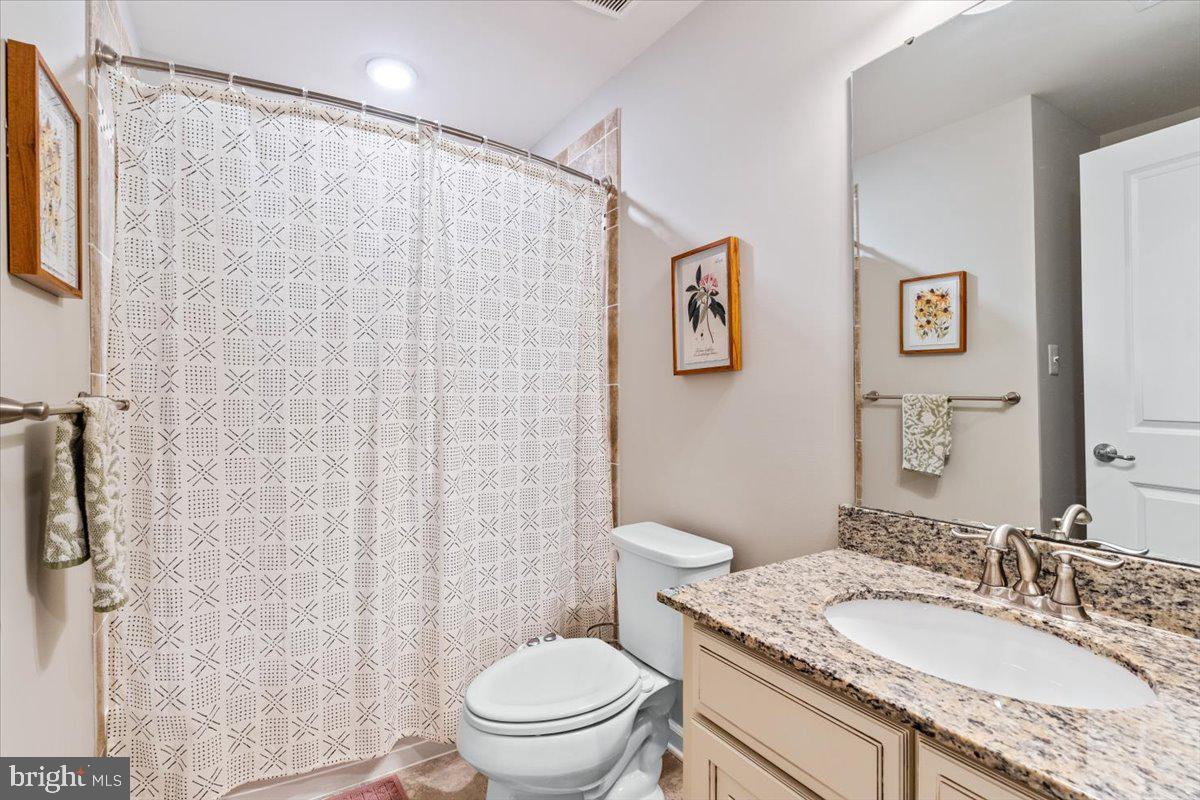 4535 Tinder Monrovia, MD 21770 - Photo 35 of 61 a bathroom with a granite countertop toilet a sink and a mirror