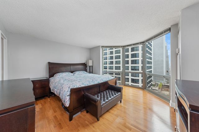 a spacious bedroom with a bed window and a couch