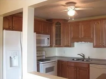 a kitchen with kitchen island granite countertop a sink stainless steel appliances and cabinets