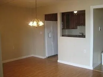 an empty room with wooden floor and mirror