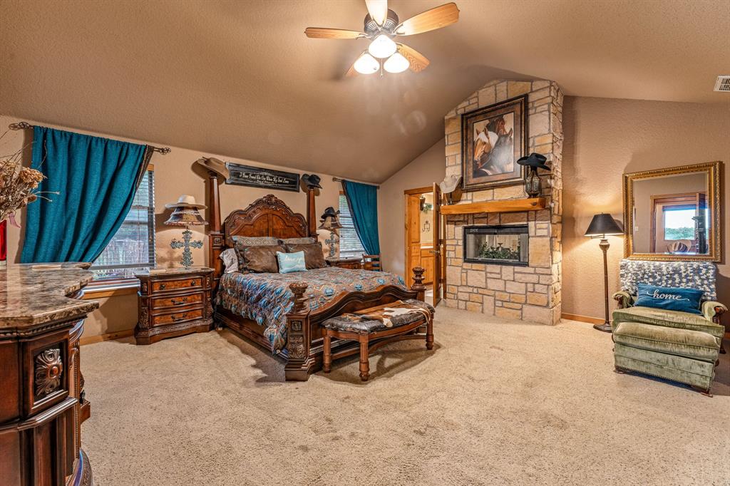 475 Magic Valley Bluff Dale, TX 76433 - Photo 16 of 40 a spacious bedroom with a bed a couch and dresser