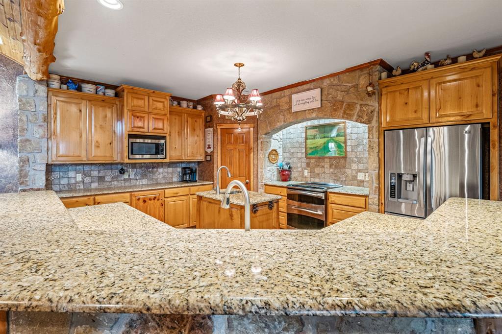 475 Magic Valley Bluff Dale, TX 76433 - Photo 10 of 40 a large kitchen with stainless steel appliances kitchen island granite countertop a sink and cabinets