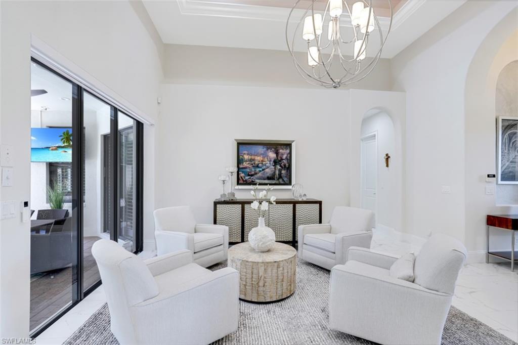 7323 Acorn Way Naples, FL 34119 - Photo 8 of 21 Sitting room featuring chandelier lighting, tile floors and a high ceiling