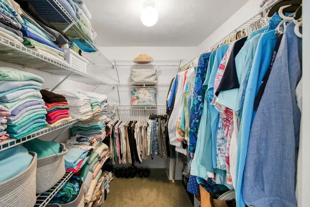 a view of walk in closet with clothes