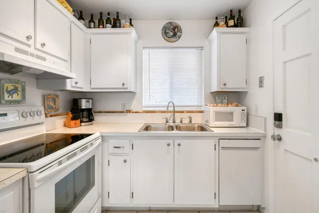 a kitchen with cabinets appliances a sink and a stove