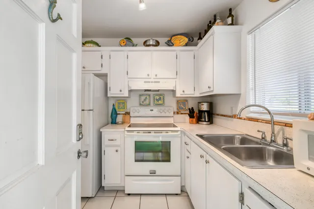 a kitchen with stainless steel appliances granite countertop white cabinets and a sink