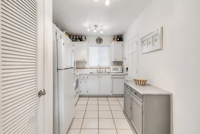 a kitchen with white cabinets and white appliances