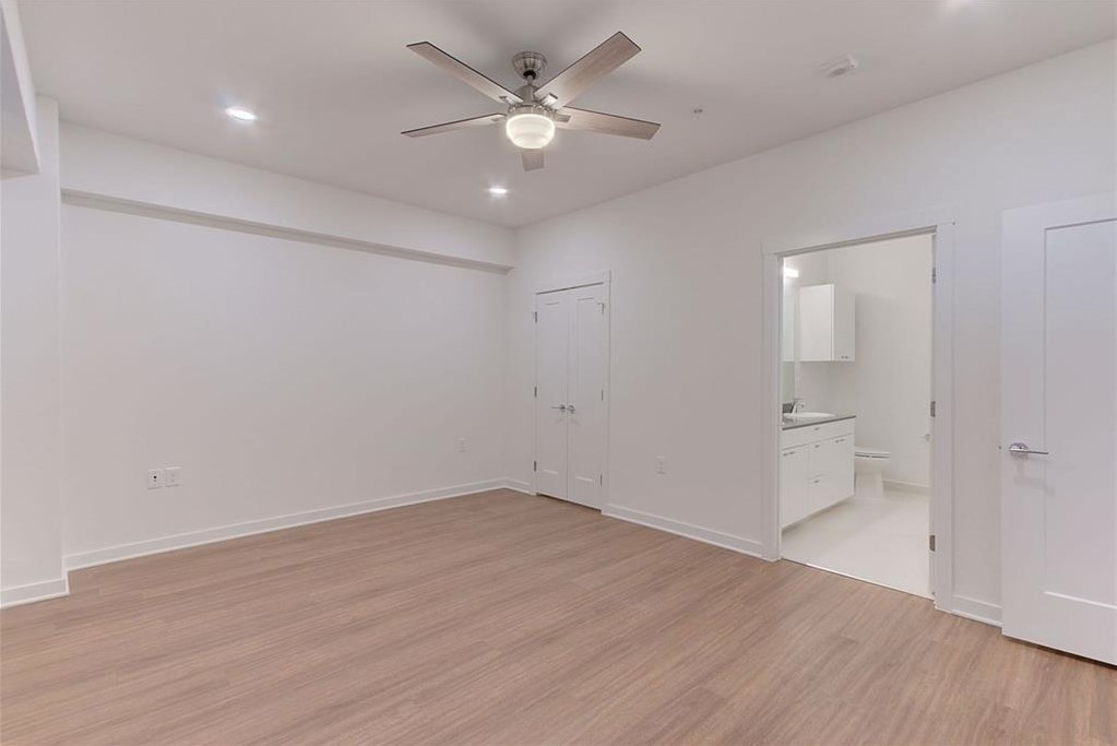 4361 South Congress Avenue, Unit 210 Austin, TX 78745 - Photo 11 of 30 an empty room with wooden floor and a ceiling fan
