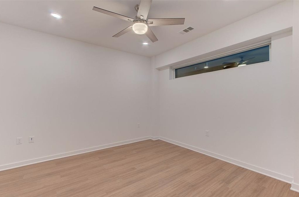 4361 South Congress Avenue, Unit 210 Austin, TX 78745 - Photo 13 of 30 an empty room with wooden floor and ceiling fan