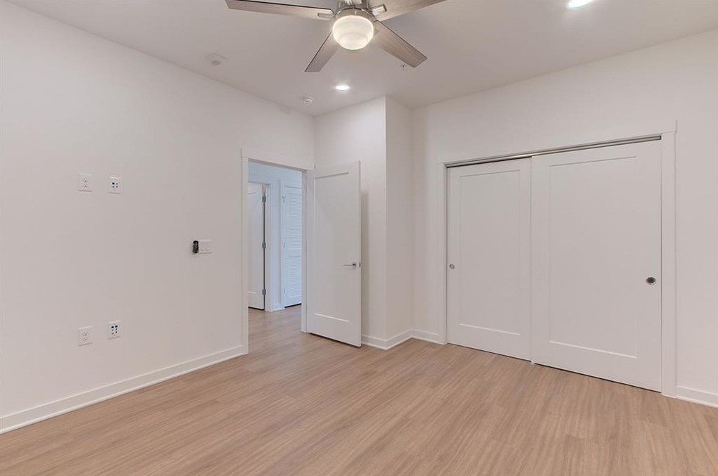 4361 South Congress Avenue, Unit 210 Austin, TX 78745 - Photo 14 of 30 an empty room with wooden floor and fan