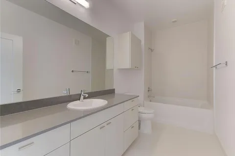 an empty room with wooden floor and fan