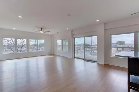 an empty room with wooden floor and balcony