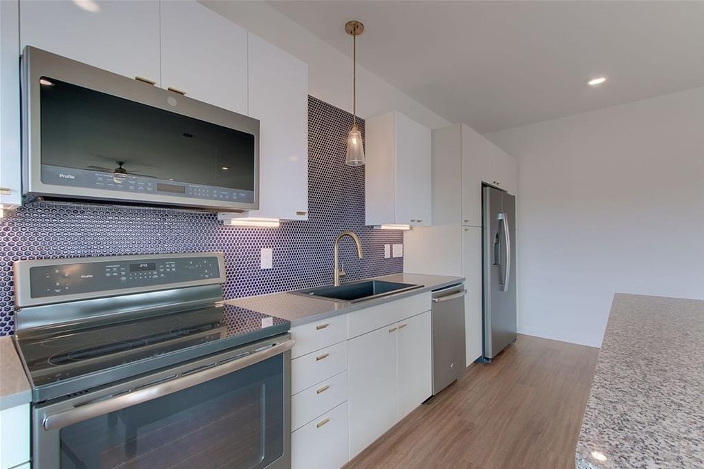 4361 South Congress Avenue, Unit 210 Austin, TX 78745 - Photo 3 of 30 a kitchen with granite countertop a sink and cabinets