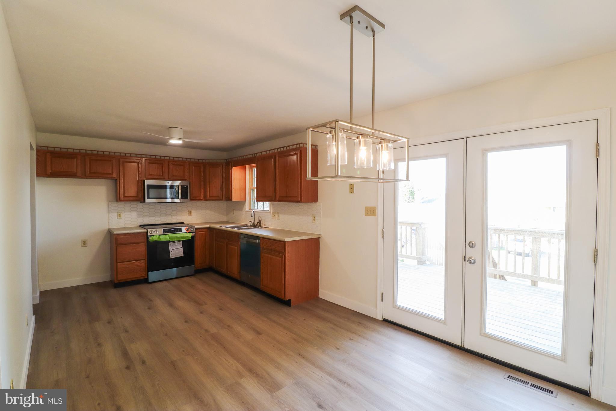 552 Locust Street Hanover, PA 17331 - Photo 3 of 32 a kitchen with stainless steel appliances kitchen island granite countertop a refrigerator a oven a sink and a wooden floors