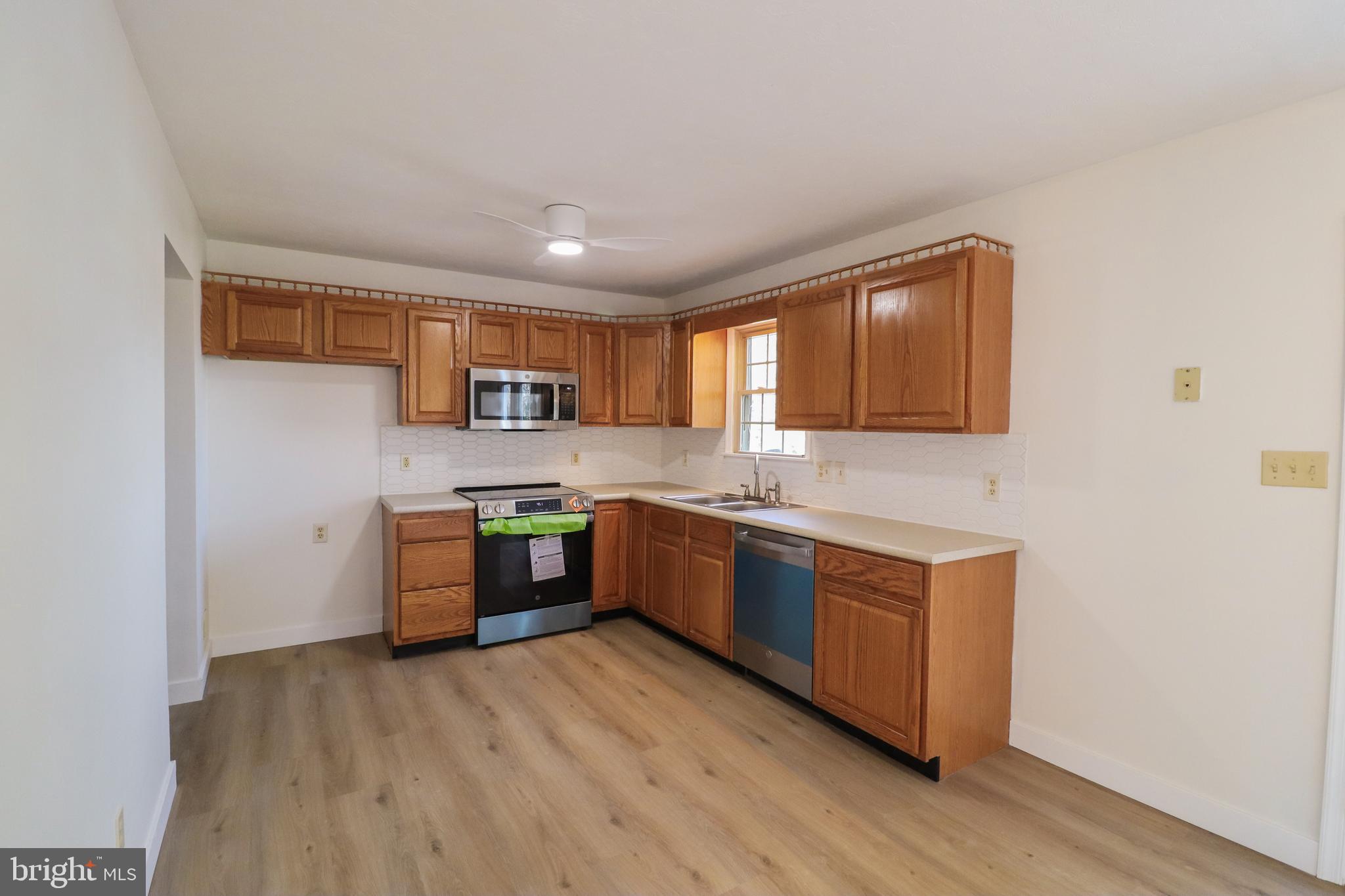 552 Locust Street Hanover, PA 17331 - Photo 5 of 32 a kitchen with stainless steel appliances granite countertop a sink cabinets and wooden floor