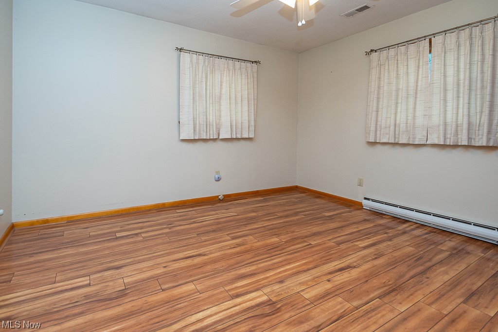 5 Pleasantview Vermilion, OH 44089 - Photo 17 of 37 Empty room with light hardwood / wood-style flooring, ceiling fan, and a baseboard radiator