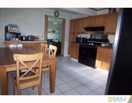 29 Brookville Road Edison, NJ 08817 - Photo 3 of 10 a kitchen with a table chairs refrigerator and a cabinets