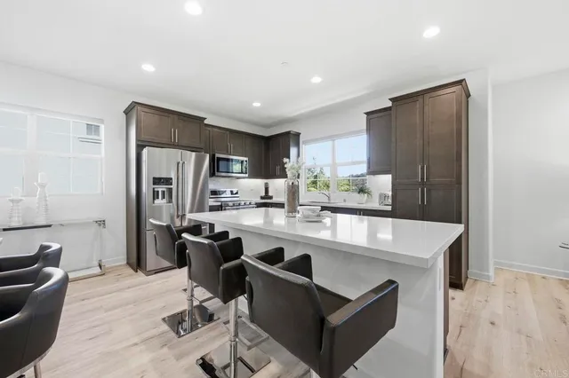 a large kitchen with kitchen island a refrigerator a stove a sink a dining table and chairs