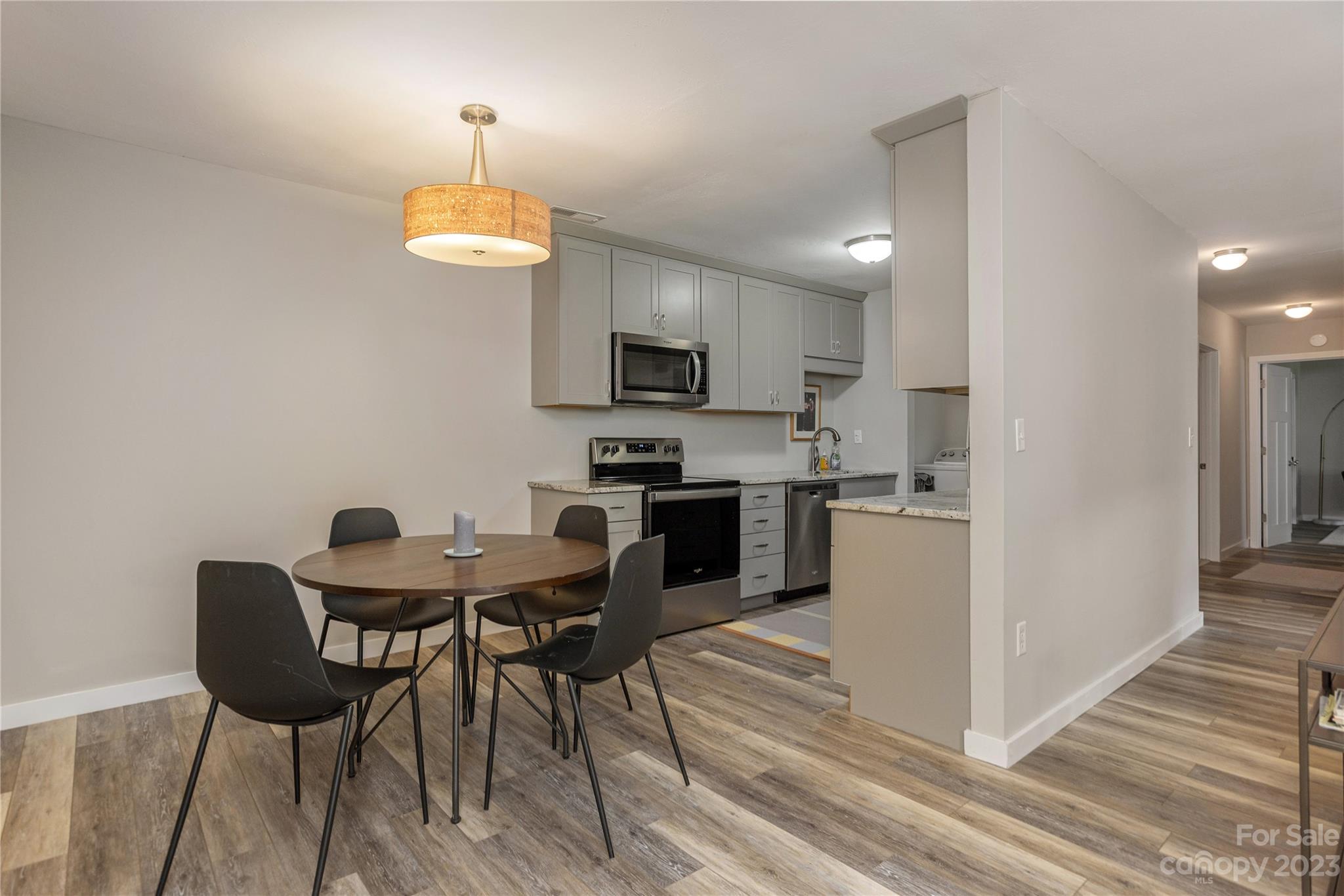 111 Shepard Square, Unit 608 Brevard, NC 28712 - Photo 6 of 13 a kitchen with a dining table chairs and a refrigerator