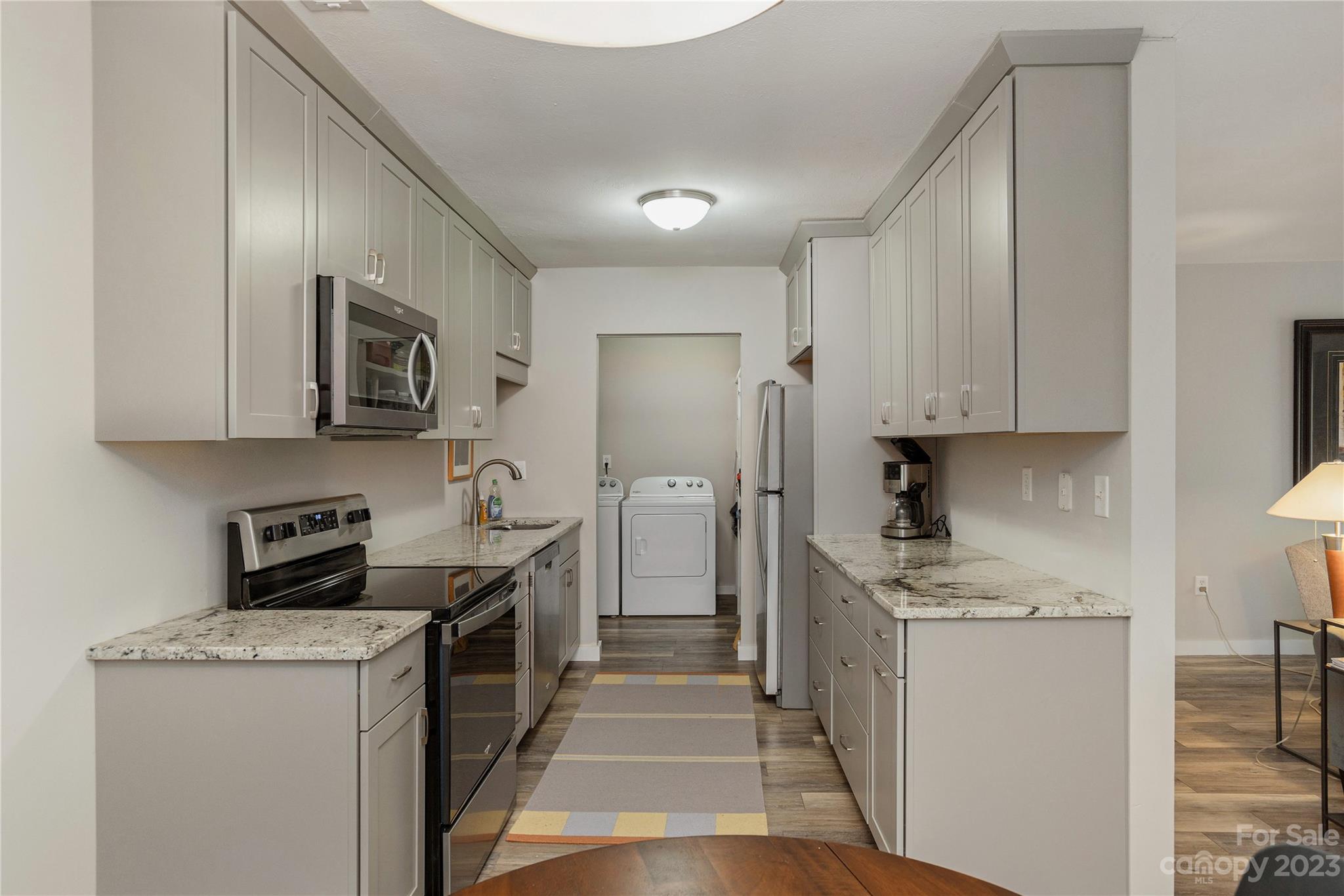 111 Shepard Square, Unit 608 Brevard, NC 28712 - Photo 7 of 13 a kitchen with stainless steel appliances granite countertop a stove a sink and a refrigerator