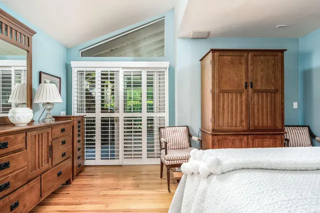 a bedroom with furniture and large windows