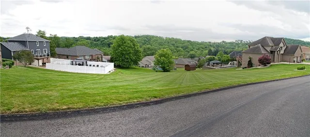 a view of a house with a big yard potted plants and large trees