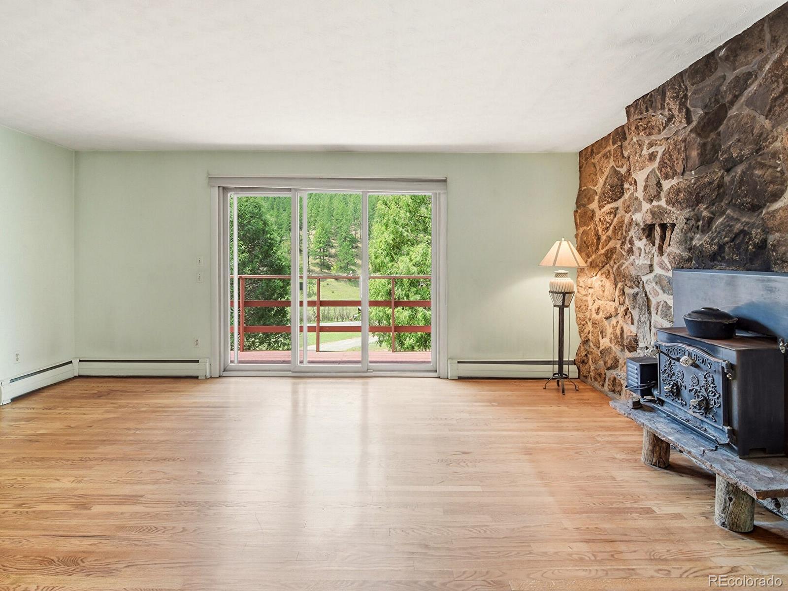 2830 Kerr Gulch Road Evergreen, CO 80439 - Photo 12 of 48 a view of an empty room with a fireplace and a window
