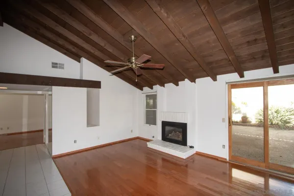 a view of empty room with wooden floor and fireplace