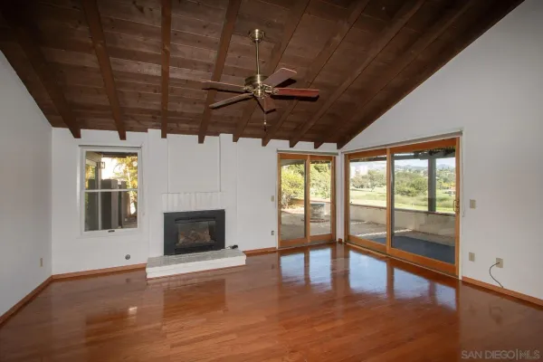 a living room with wooden floors and fireplace