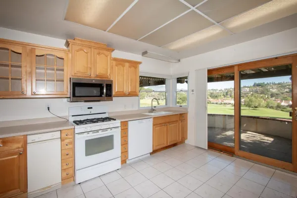 a kitchen with stainless steel appliances granite countertop a stove a sink and a microwave