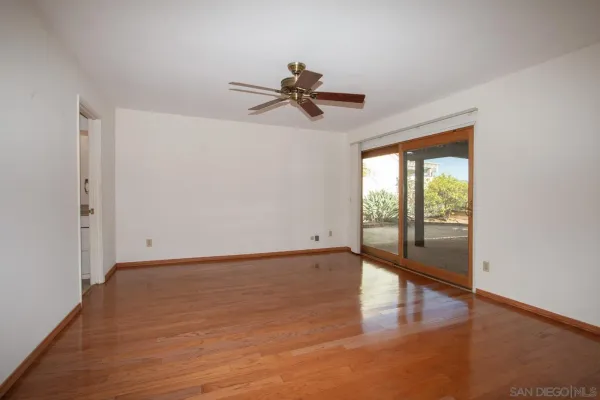 a view of a room with wooden floor and a window