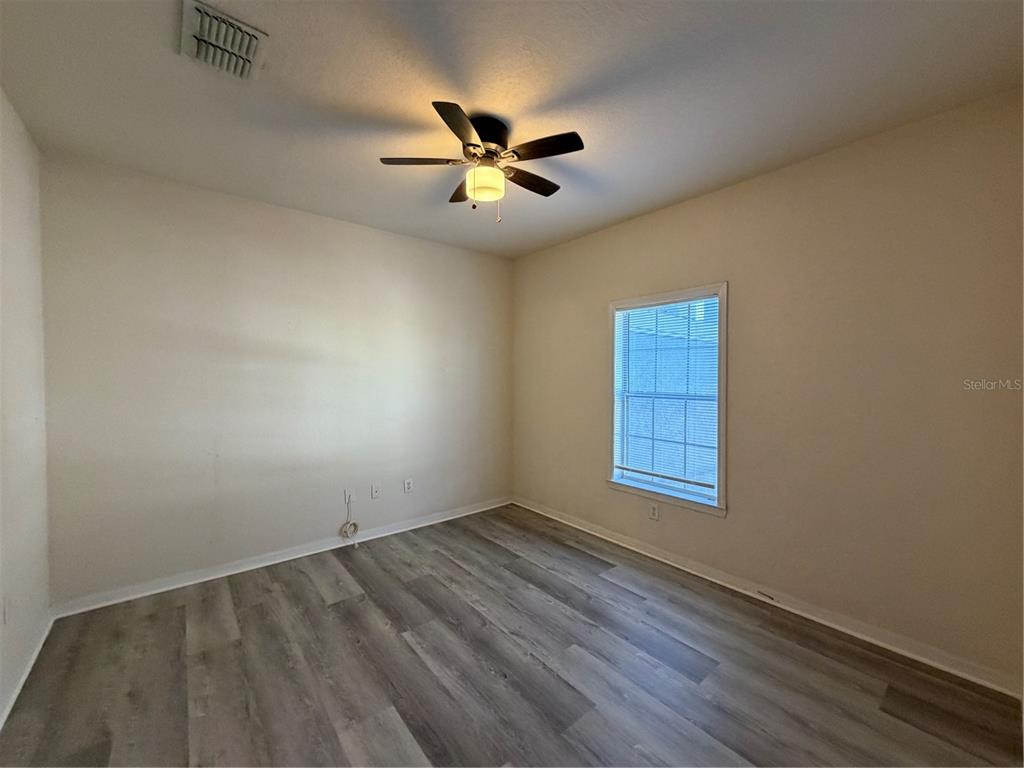 3561 Conroy Road, Unit 225 Orlando, FL 32839 - Photo 9 of 14 an empty room with wooden floor fan and windows