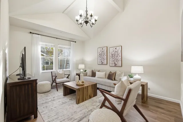 a living room with furniture a large window and a flat screen tv