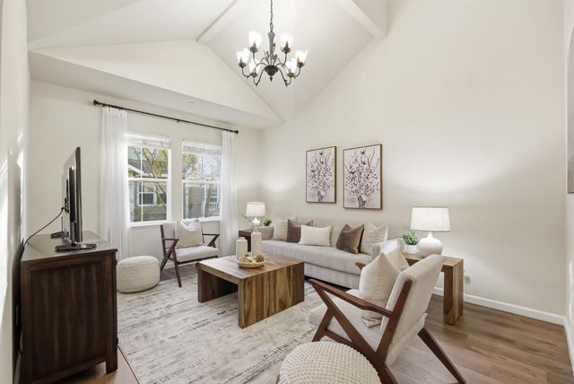 a living room with furniture a large window and a flat screen tv